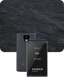 Two black Vasco Translators Q1 shown from the front and back against a black textured stone background. The front screen displays 